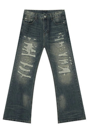 Distressed flare jeans in medium wash denim with graffiti-style rips and patches.