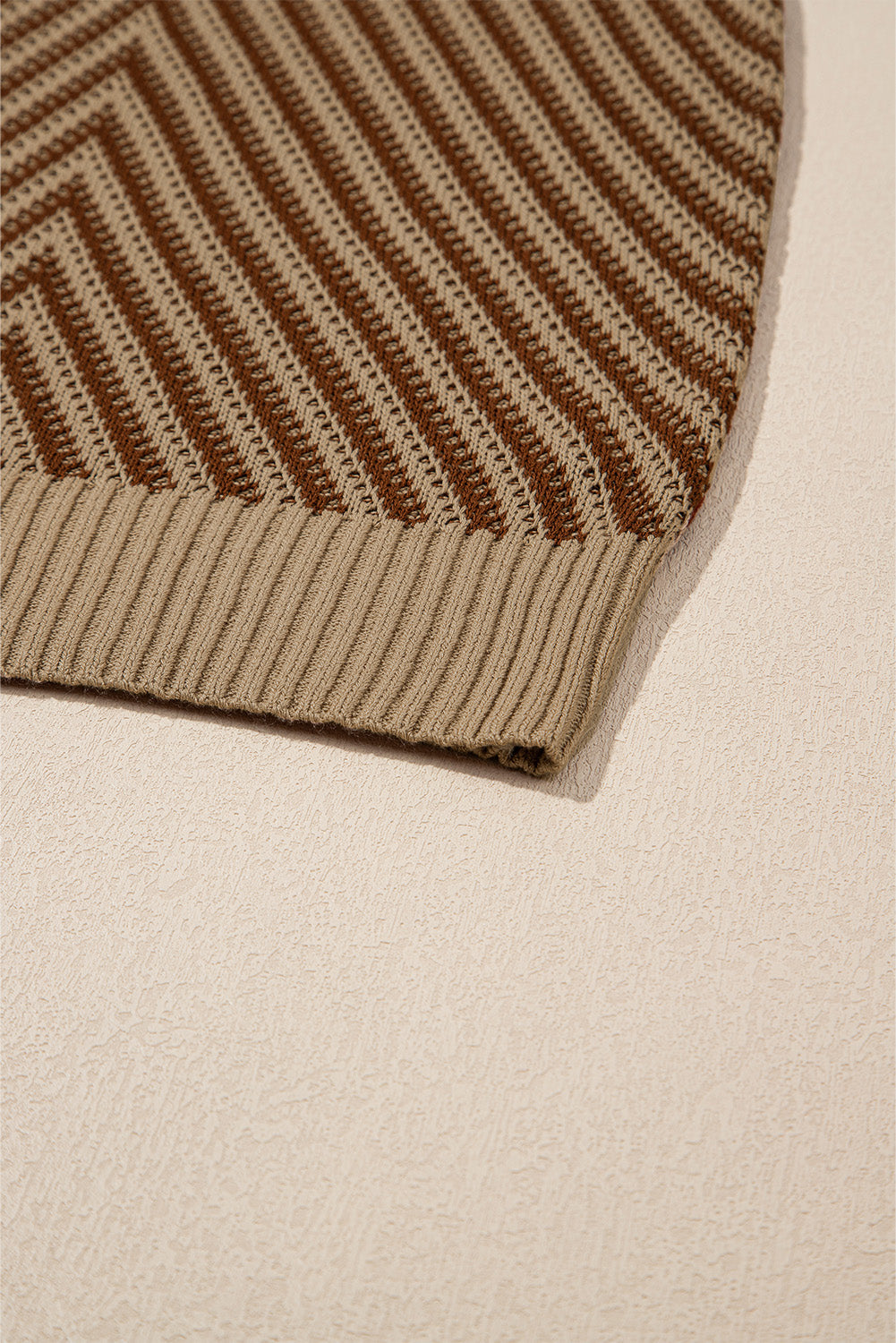 Chevron knit vest in brown and tan with ribbed hem detail.