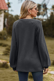 Dark Gray waffle knit raglan top with textured sleeves and V-neck.