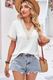 White eyelet V-neck blouse with lace trim and short sleeves.