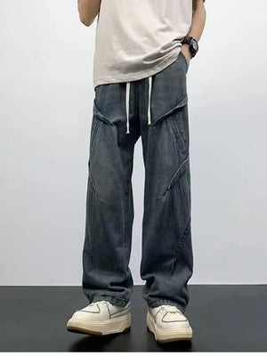 Gray oversized drawstring jeans with contemporary paneling and a relaxed fit.