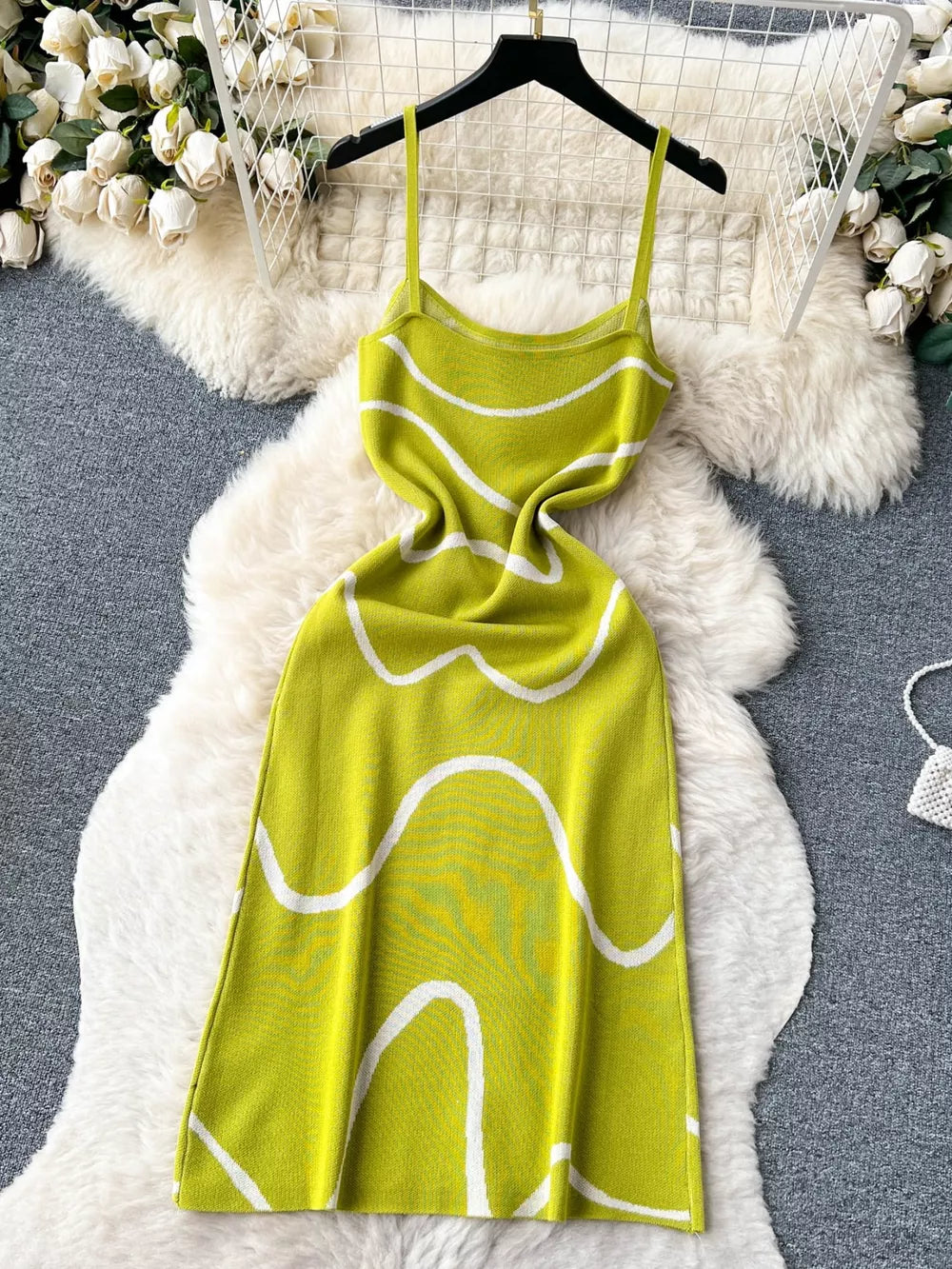 Green wavy knit midi dress with spaghetti straps and white abstract pattern.