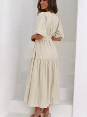 Cream midi dress with puff sleeves, elastic waist, and tiered skirt.
