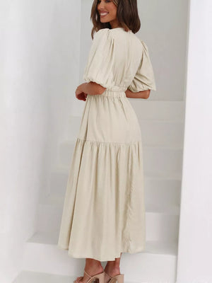 Cream midi dress with puff sleeves, elastic waist, and tiered skirt.