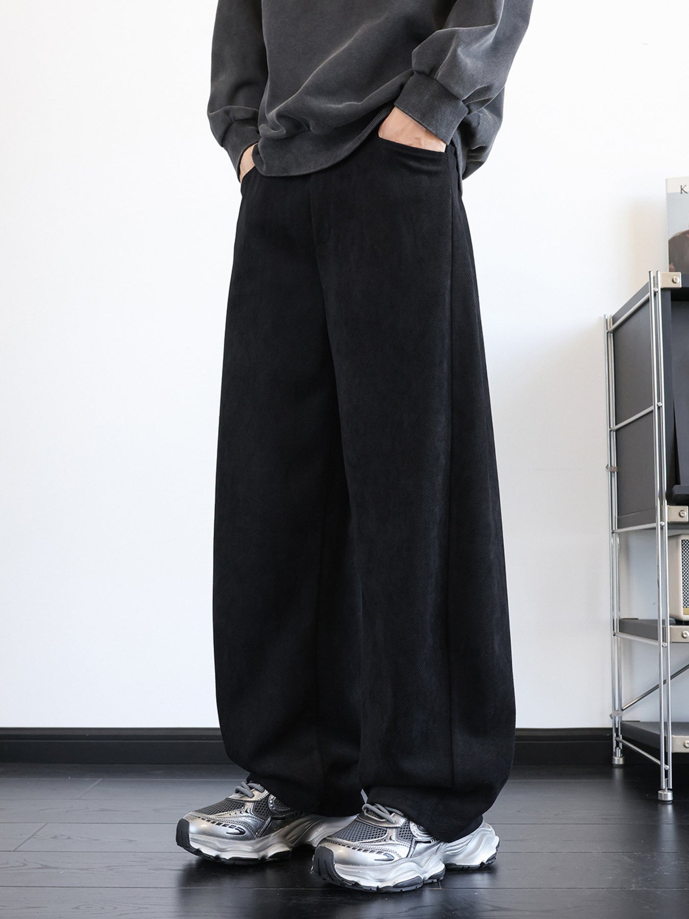 Men's black wide-leg sweatpants with pockets, relaxed fit, and textured fabric.