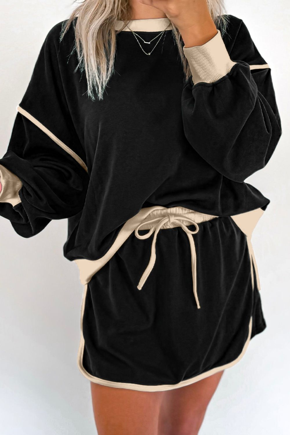 Black sweatshirt and skort set with contrast trim and drawstring waist.
