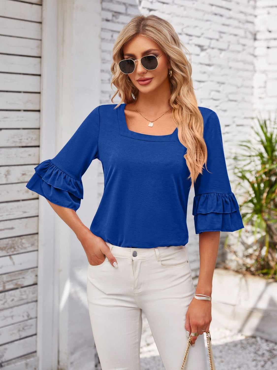 Royal blue blouse with square neckline and ruffled bell sleeves.