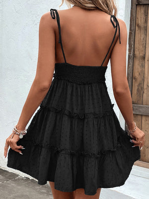 Black dotted swiss tiered mini dress with tie straps and smocked bodice.