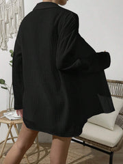 Black textured gauze shirt with buttoned front and collar, styled casually.