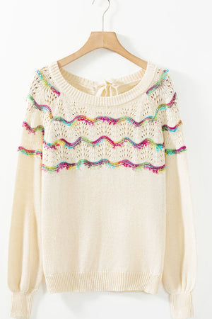 Cream knit sweater with rainbow scallop detail and back tie, crew neck, long sleeves.