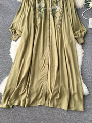 Khaki cotton maxi dress with embroidered floral detail and tie neck.