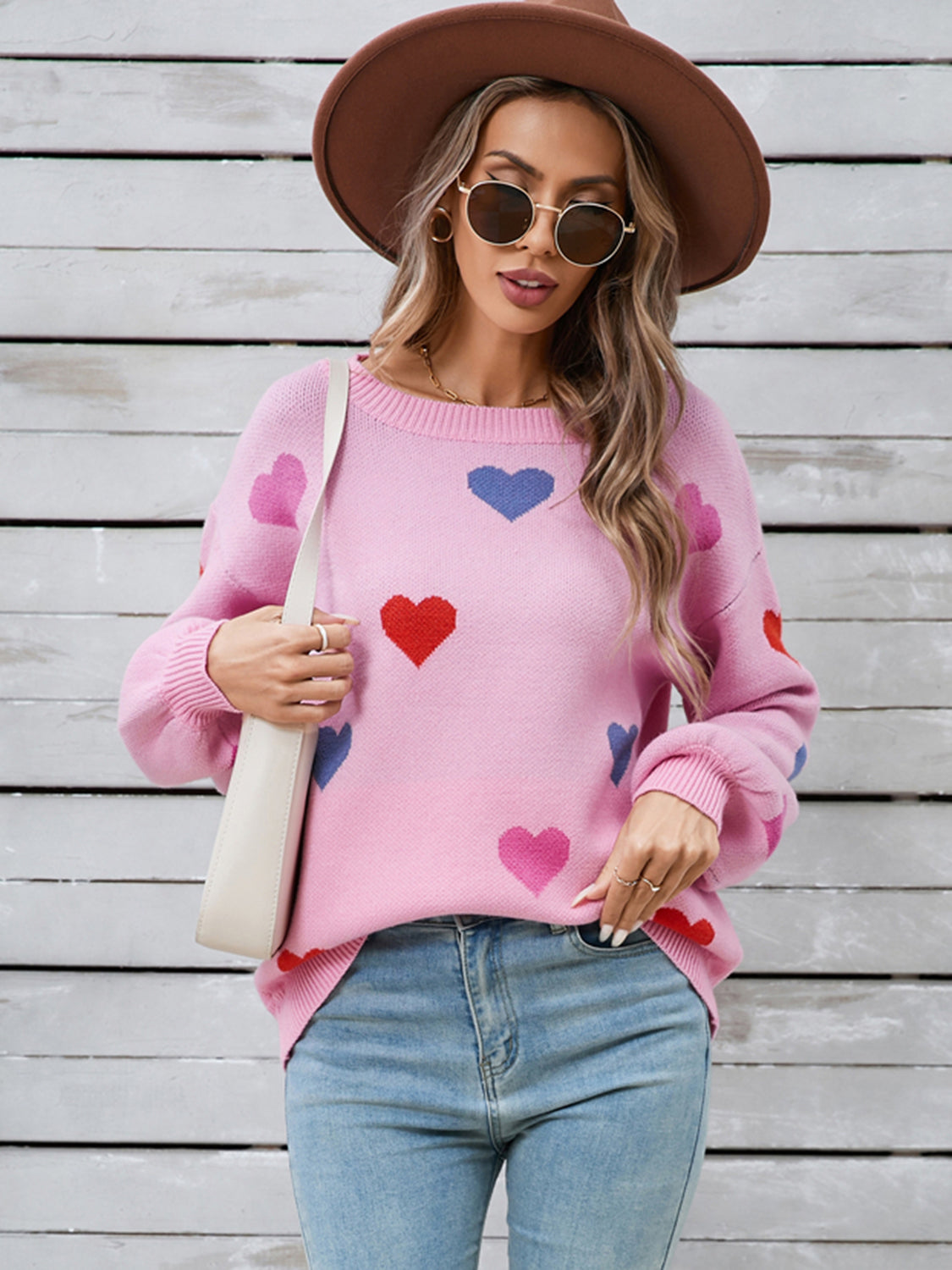 Pink acrylic knit sweater with allover heart motif and bubble sleeves