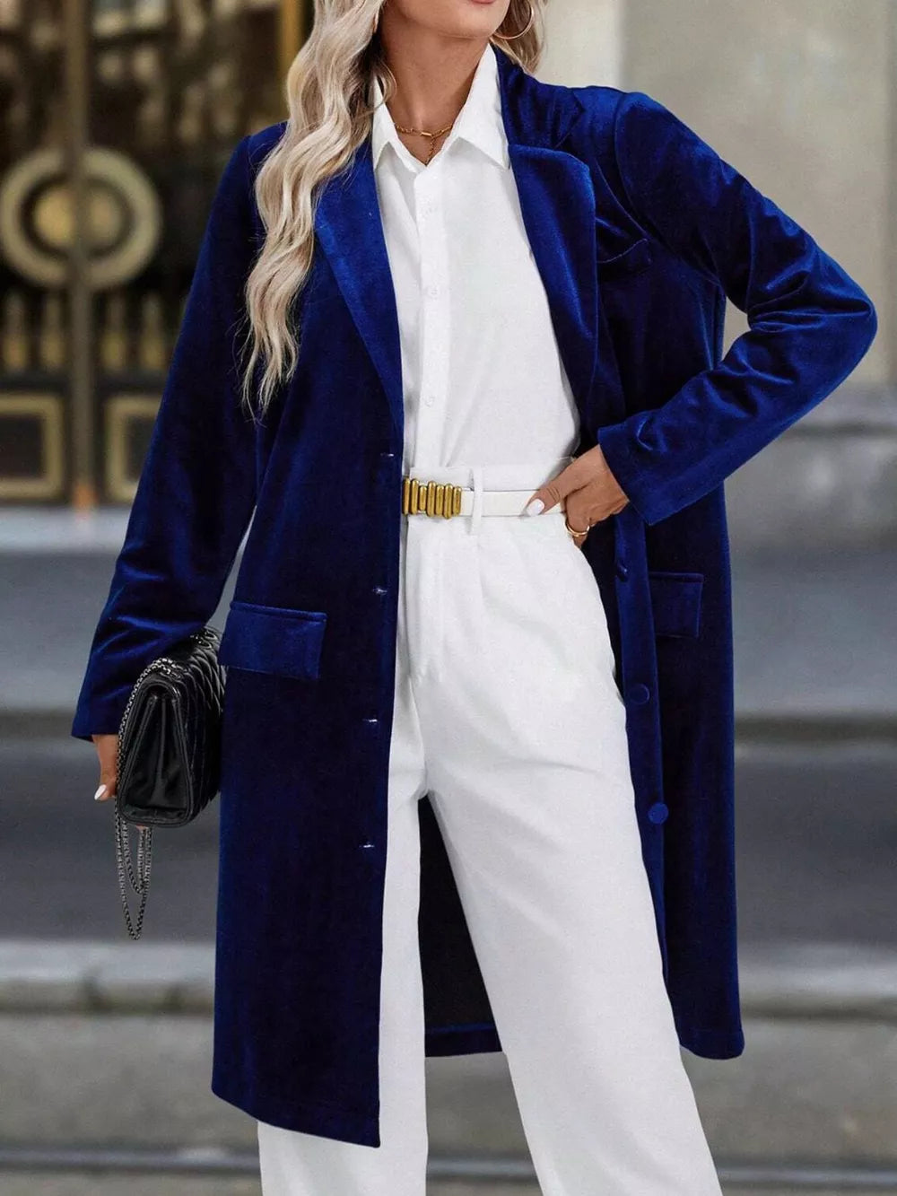 Longline trench coat in dark blue velvet with lapel collar and buttoned front.