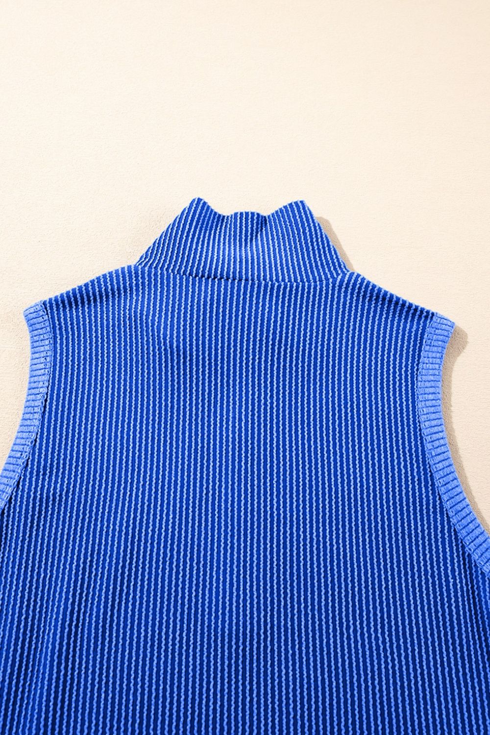Royal blue ribbed knit sleeveless turtleneck top with vertical pinstripe texture.