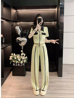 Chic beige zip-up top and wide-leg pants set with black trim and collar.