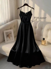 Black satin cami dress with pearl straps and a zipper detail.