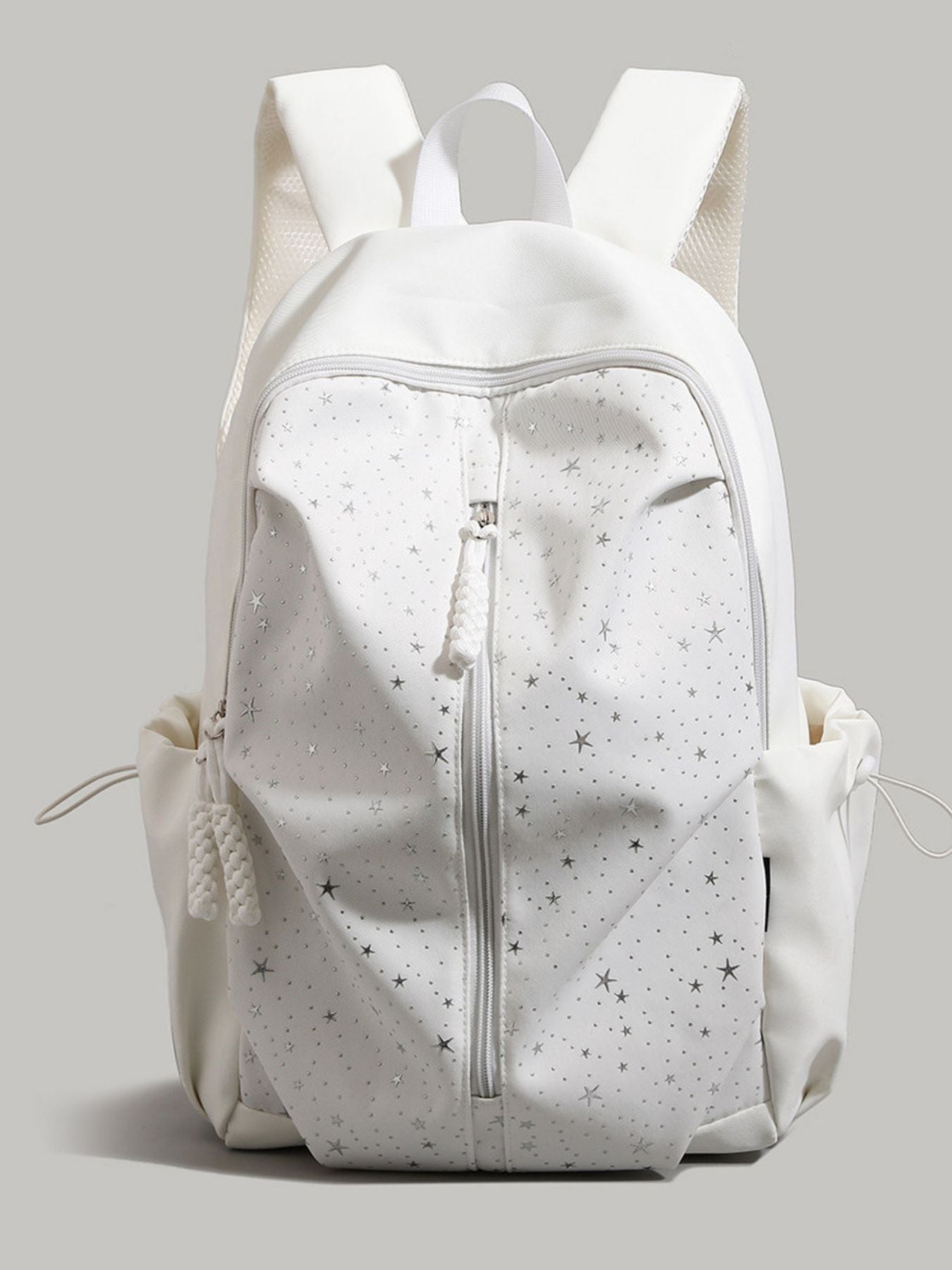 White nylon school backpack with silver stars pattern and braided zipper pull.