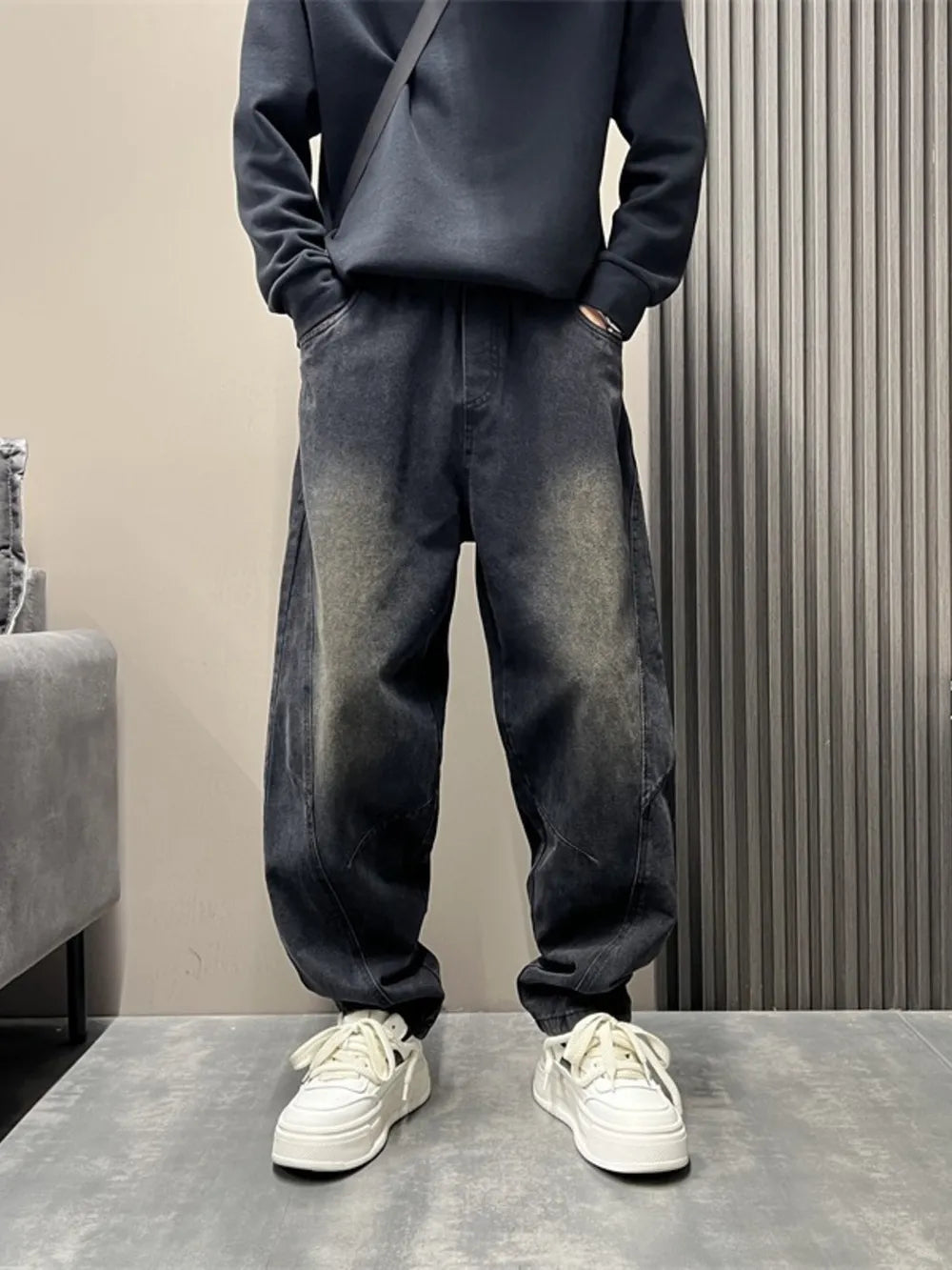Men's oversized washed black tapered jeans with a baggy fit.