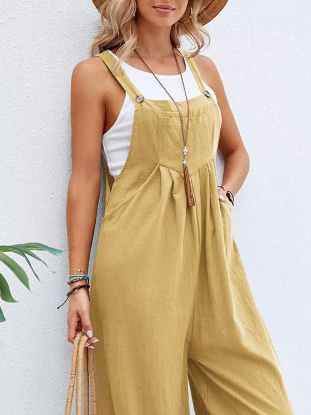 Light Yellow wide-leg romper with adjustable straps, button details, and pockets, styled with a white tank top.