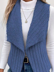 Blue fleece vest with open front and ribbed texture, worn over a white turtleneck.