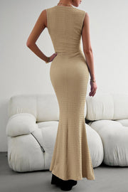 Sand textured maxi dress with a fishtail hem, sleeveless, and crew neck.