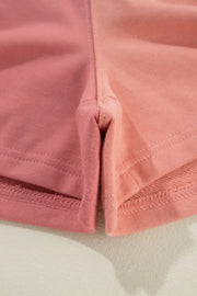 Colorblock lounge shorts in dusty pink with contrast stitching and a ribbed hem detail.