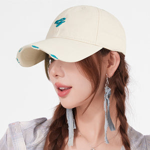 Off-white distressed cotton baseball cap with blue embroidery and frayed details.