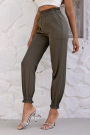 Olive brown gathered waistband cuffed jogger trousers with ruffled ankles.