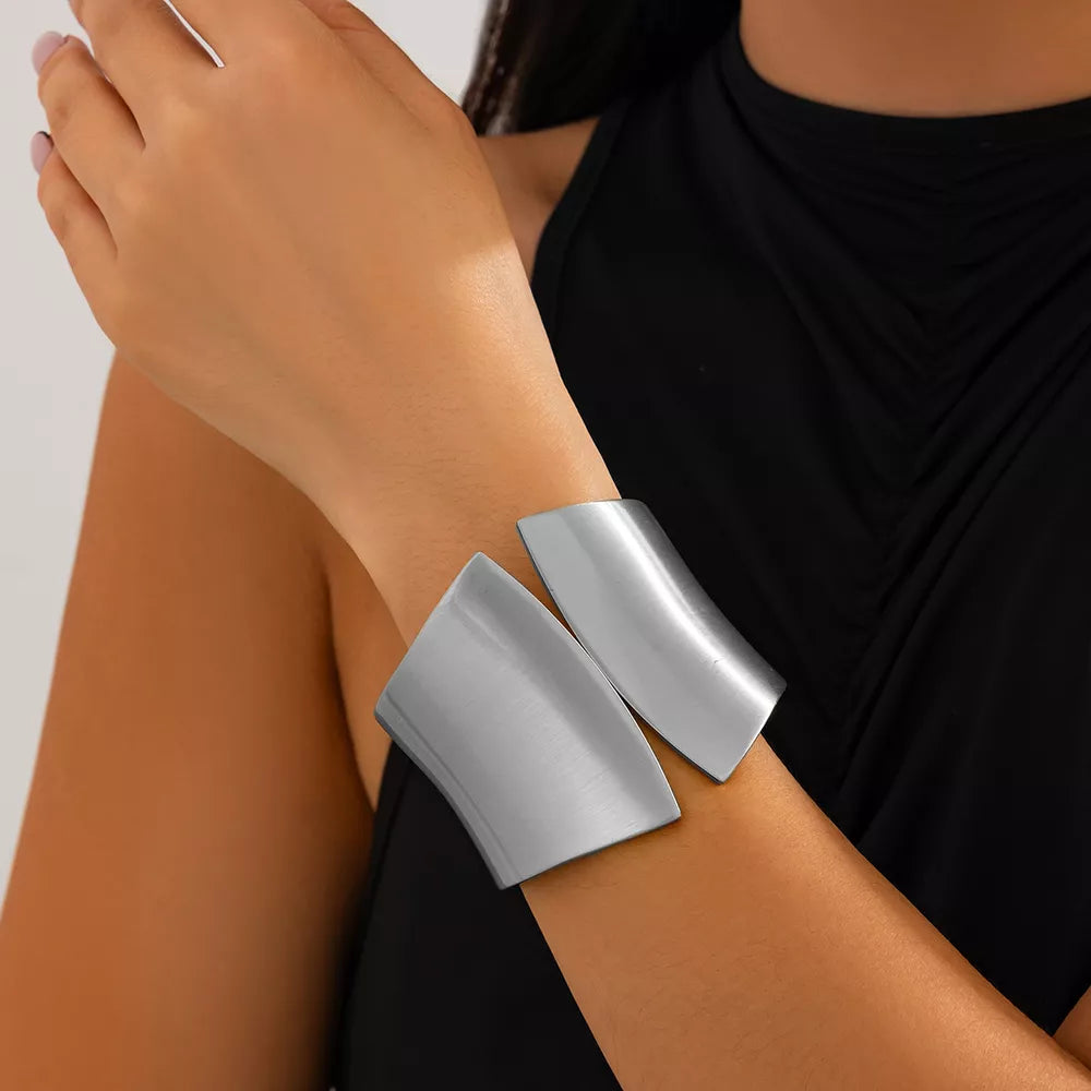 Sculptural silver-toned cuff bracelet with a modern, open design.