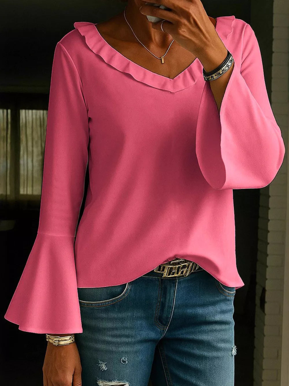 Fuchsia pink polyester blouse with ruffled V-neck and dramatic bell sleeves.