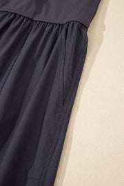 Dark gray jumpsuit with gathered waist and side pockets.