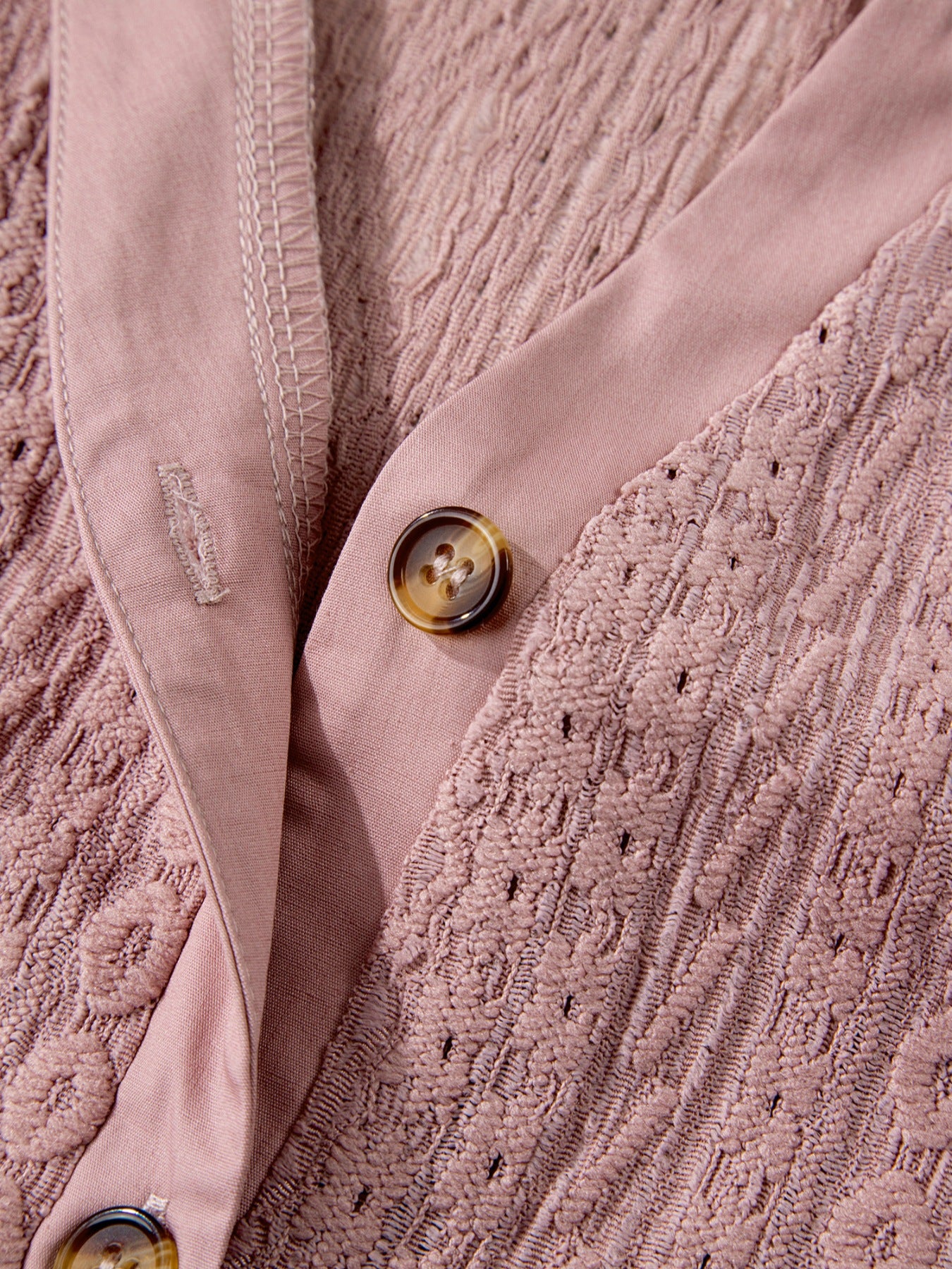 Pink eyelet embroidered blouse with button front and tortoise shell buttons.