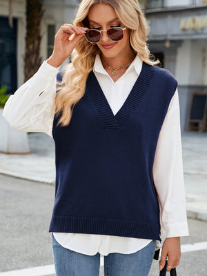 Dark blue ribbed knit v-neck sweater vest with a relaxed fit, layered over a white collared shirt.
