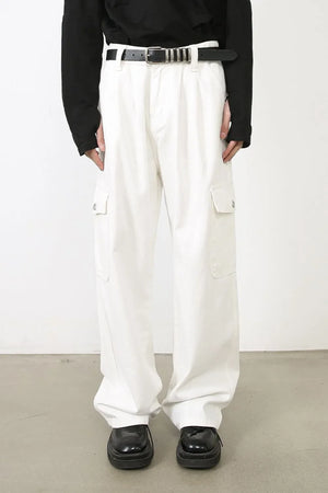 White 100% cotton pleated cargo pants with wide leg cut and utility pockets.