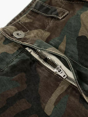 Distressed camouflage cargo pants with a metal zipper and button closure.
