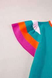 Teal knit blouse with flutter sleeves and colorblock trim in pink, orange, and white.
