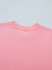 Pink knit top with ribbed mock neck and scalloped hem detail.