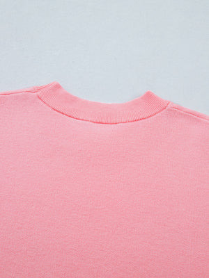 Pink knit top with ribbed mock neck and scalloped hem detail.