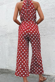 Red polka dot halter neck palazzo jumpsuit with belted waist.