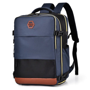 Dusty blue and black travel backpack with contrast panels and brown faux leather trim.