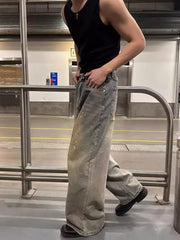 Vintage wash distressed wide-leg jeans with paint splatters and a belted waist.