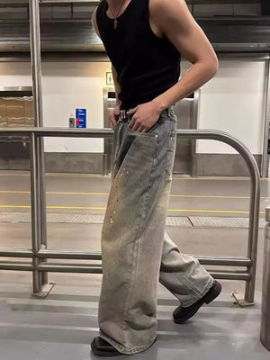 Vintage wash distressed wide-leg jeans with paint splatters and a belted waist.