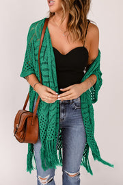 Green open knit chevron fringe cardigan with short sleeves and open front, styled with jeans and a crossbody bag.