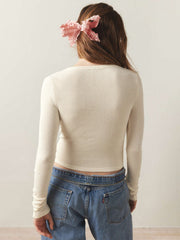 Cream ribbed long sleeve crop top with a crew neck, styled with jeans.