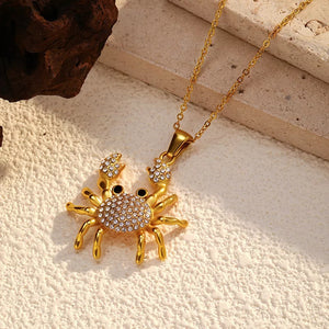 Gold-plated crab pendant necklace with crystal accents and a delicate chain.