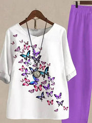 White half sleeve top with multicolor butterfly print and purple pants.