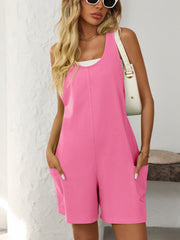 Pink sleeveless utility romper with seam details and patch pockets.