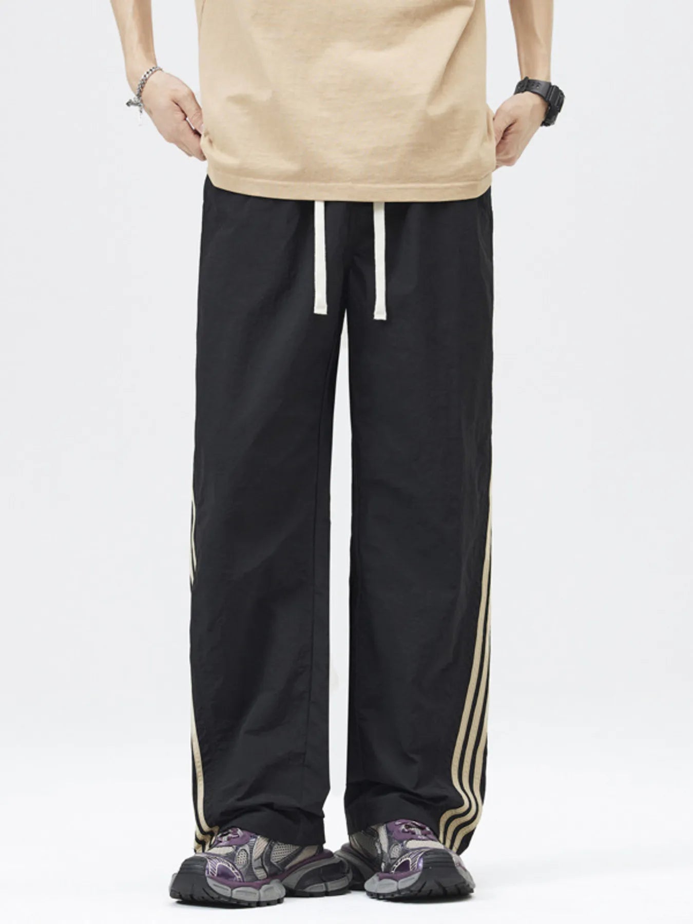 Casual loose fit drawstring pants in Noirnoir with side stripes and white drawstring.