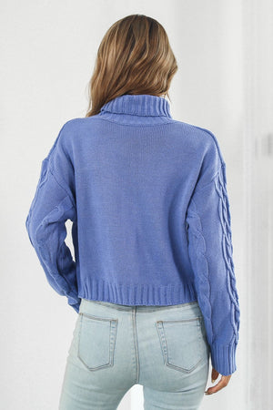 Blue acrylic cable knit cropped turtleneck sweater with braided sleeves.