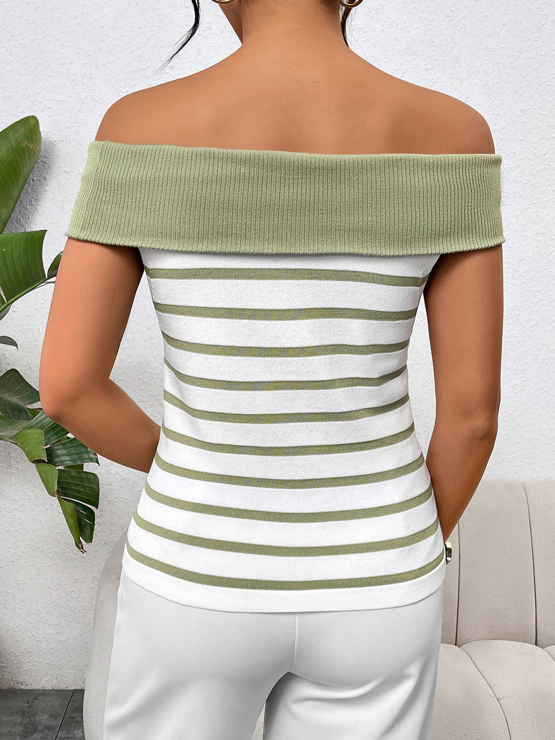 Off-shoulder knit top with green and white stripes and a ribbed neckline.